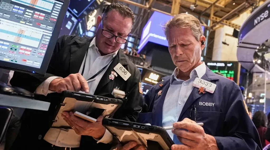 Wall Street eases as stocks retreat from record highs; Fed Chair warns valuations are stretched while gold prices set new records. - AP Photo/Richard Drew