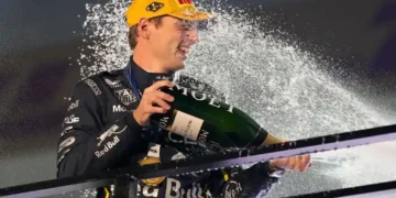 Max Verstappen leads the Las Vegas Grand Prix under bright night lights as McLaren cars trail behind. - AP Photo/John Locher