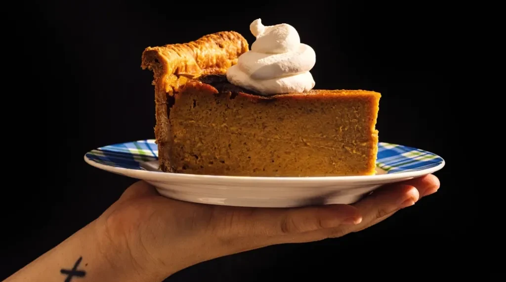 Tall deep-dish pumpkin pie sliced on table with skillet - Alanna Hale/Voracious via AP
