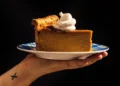 Tall deep-dish pumpkin pie sliced on table with skillet - Alanna Hale/Voracious via AP