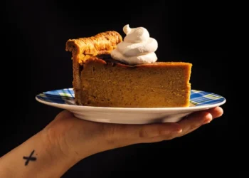 Tall deep-dish pumpkin pie sliced on table with skillet - Alanna Hale/Voracious via AP