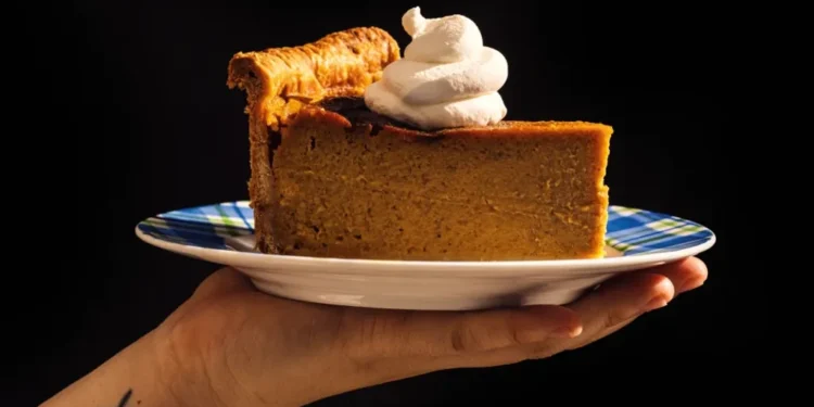 Tall deep-dish pumpkin pie sliced on table with skillet - Alanna Hale/Voracious via AP