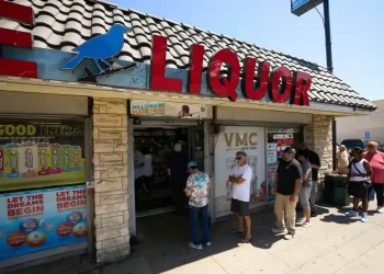 Winning Powerball and Mega Millions tickets stacked on a table - AP Photo/Damian Dovarganes, File