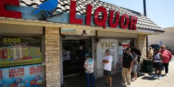 Winning Powerball and Mega Millions tickets stacked on a table - AP Photo/Damian Dovarganes, File