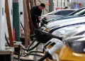 Oil pumps contrasted with electric vehicles and wind turbines in China - Florence Lo/Reuters/File