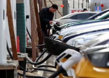 Oil pumps contrasted with electric vehicles and wind turbines in China - Florence Lo/Reuters/File
