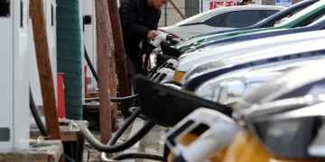 Oil pumps contrasted with electric vehicles and wind turbines in China - Florence Lo/Reuters/File