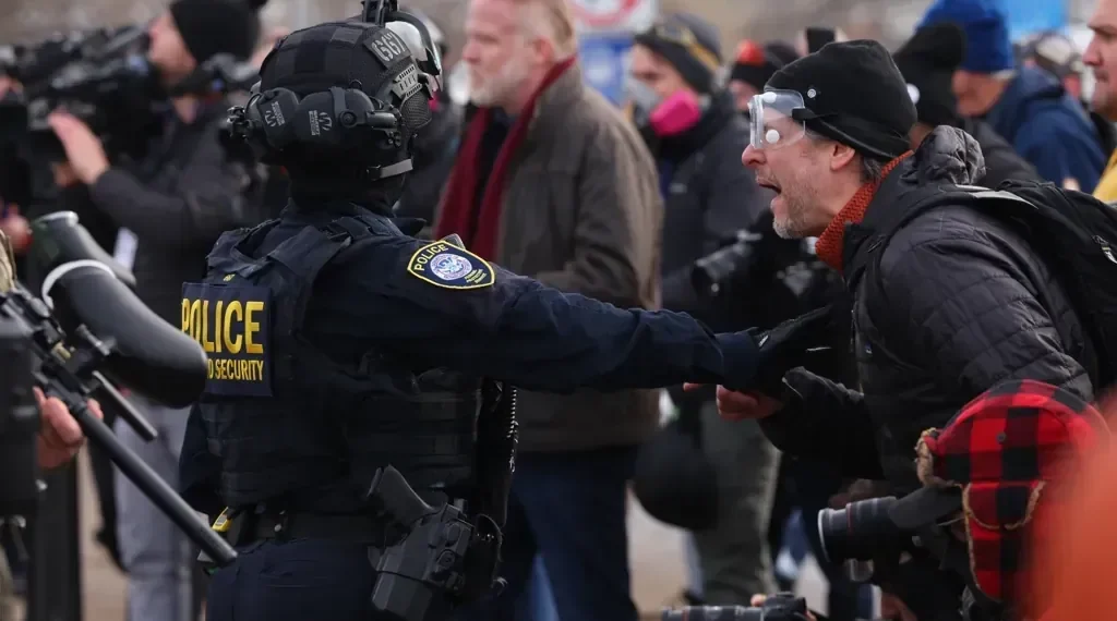 Minnesota ICE shooting scene with police vehicles and protesters - AP Photo/Adam Bettcher
