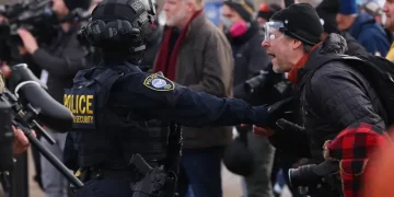 Minnesota ICE shooting scene with police vehicles and protesters - AP Photo/Adam Bettcher