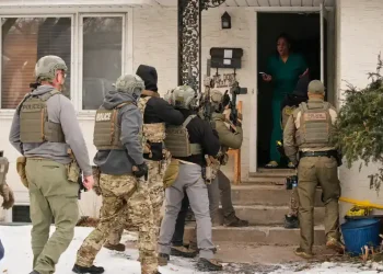 ICE officers conducting immigration enforcement at a residential home - AP Photo/John Locher