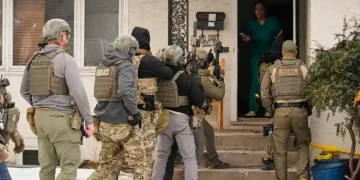 ICE officers conducting immigration enforcement at a residential home - AP Photo/John Locher