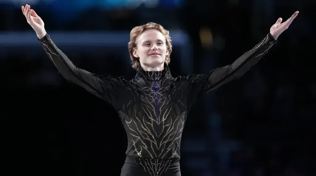 Ilia Malinin performing quad jump during elite figure skating competition - AP Photo/Stephanie Scarbrough