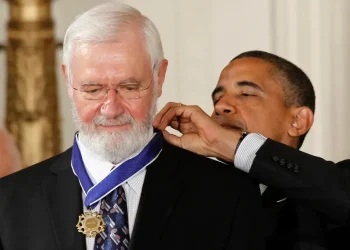 Dr. William Foege, smallpox eradication pioneer, smiling at public health event - AP Photo/Charles Dharapak, File