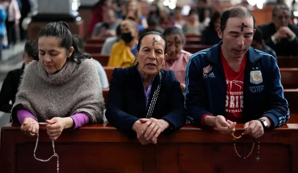 Ash cross and Ramadan lantern symbolizing fasting seasons - AP Photo/Fernando Vergara, File