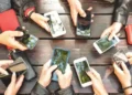 Smartphone showing active group chat messages with icons - Photo by View Apart/Canva