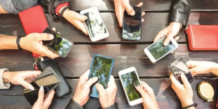 Smartphone showing active group chat messages with icons - Photo by View Apart/Canva