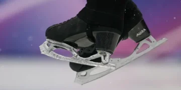 Olympic figure skater landing jump on hard ice - AP Photo/Ashley Landis