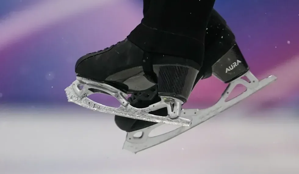 Olympic figure skater landing jump on hard ice - AP Photo/Ashley Landis