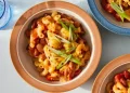 Bowl of slow cooker chili mac topped with cheese and green onions - Kristin Teig/Voracious via AP