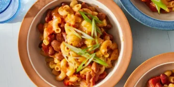 Bowl of slow cooker chili mac topped with cheese and green onions - Kristin Teig/Voracious via AP