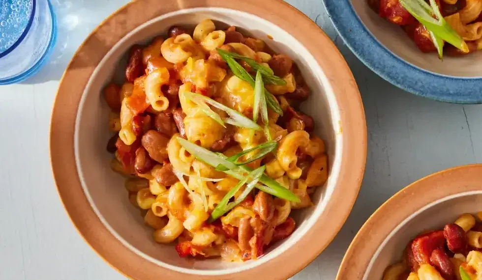Bowl of slow cooker chili mac topped with cheese and green onions - Kristin Teig/Voracious via AP