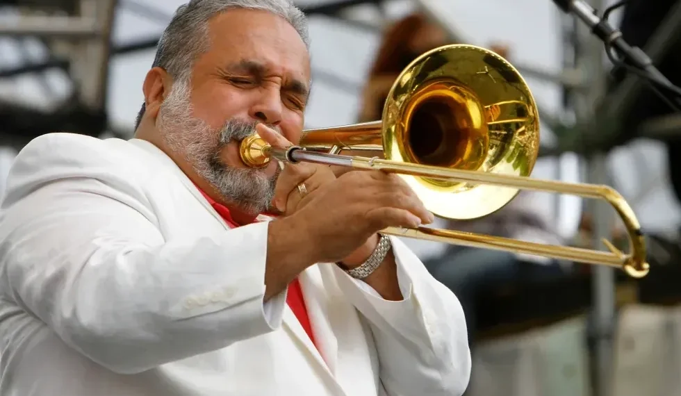 Willie Colón performing with trombone on stage - AP Photo/Jacquelyn Martin, File