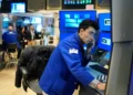 Oil barrels and stock market charts reflecting global price movements - AP Photo/Seth Wenig