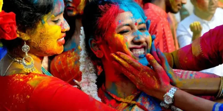 People throwing coloured powder during Holi festival in India - Getty Images