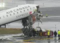 Damaged aircraft and fire truck after runway collision at LaGuardia Airport - AP Photo/Seth Wenig