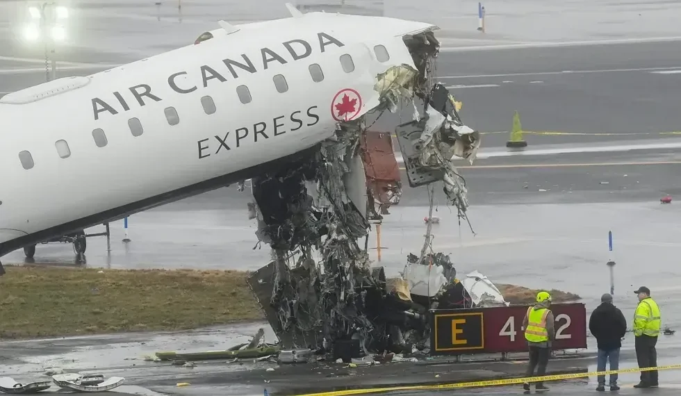 Damaged aircraft and fire truck after runway collision at LaGuardia Airport - AP Photo/Seth Wenig