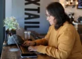 Remote worker using laptop on public Wi-Fi in a cafe - AP Photo/Cheyanne Mumphrey