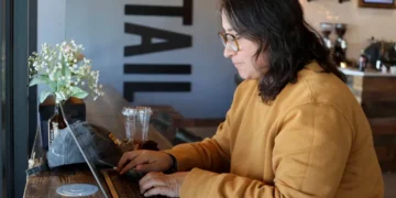 Remote worker using laptop on public Wi-Fi in a cafe - AP Photo/Cheyanne Mumphrey