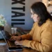 Remote worker using laptop on public Wi-Fi in a cafe - AP Photo/Cheyanne Mumphrey