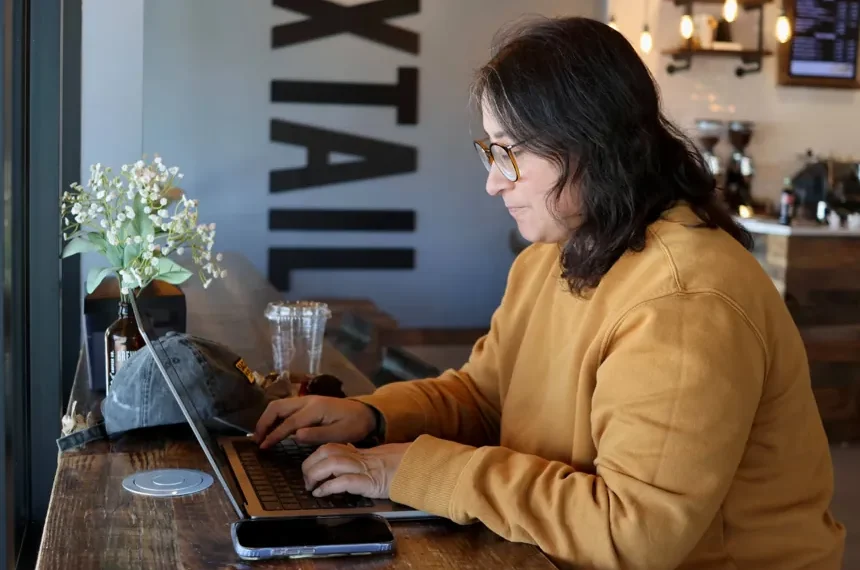 Remote worker using laptop on public Wi-Fi in a cafe - AP Photo/Cheyanne Mumphrey
