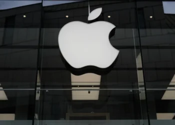 Apple logo with rising financial charts representing strong iPhone sales growth - AP Photo/Matthias Schrader, File