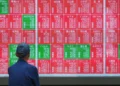 Traders monitor Asian stock markets after Wall Street reaches record highs - AP Photo/Eugine Hoshiko
