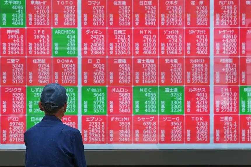 Traders monitor Asian stock markets after Wall Street reaches record highs - AP Photo/Eugine Hoshiko
