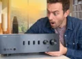 Vintage and modern hi-fi amplifiers displayed in an audio listening setup. - Image Headphonesty