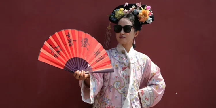 Visitors wearing imperial Chinese costumes near Beijing’s Forbidden City - AP Photo/Ng Han Guan