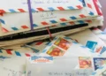 Handwritten letters and envelopes displayed beside vintage stationery materials - AP Photo/Holly Ramer