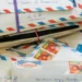 Handwritten letters and envelopes displayed beside vintage stationery materials - AP Photo/Holly Ramer