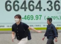 Electronic stock board displays Asian market declines amid geopolitical tensions - AP Photo/Eugene Hoshiko