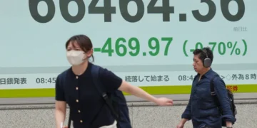 Electronic stock board displays Asian market declines amid geopolitical tensions - AP Photo/Eugene Hoshiko