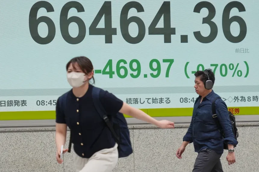 Electronic stock board displays Asian market declines amid geopolitical tensions - AP Photo/Eugene Hoshiko