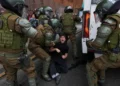 Protesters and police clash during education cuts rally in Santiago - AP Photo/Esteban Felix