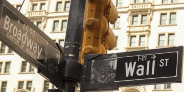 Street signs marking the intersection of Broadway and Wall Street in New York City's Financial District, a landmark associated with the U.S. financial markets.