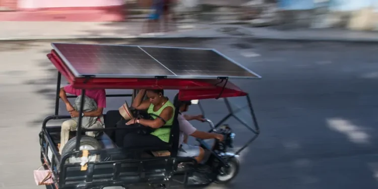 Solar-powered electric tricycles travel through the streets of Havana, Cuba. - AP Photo/Ramon Espinosa