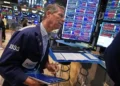 Wall Street traders monitor markets as the Dow reaches a record high. - AP Photo/Richard Drew