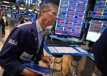 Wall Street traders monitor markets as the Dow reaches a record high. - AP Photo/Richard Drew