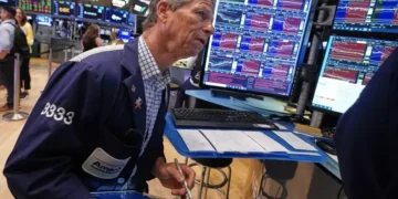 Wall Street traders monitor markets as the Dow reaches a record high. - AP Photo/Richard Drew